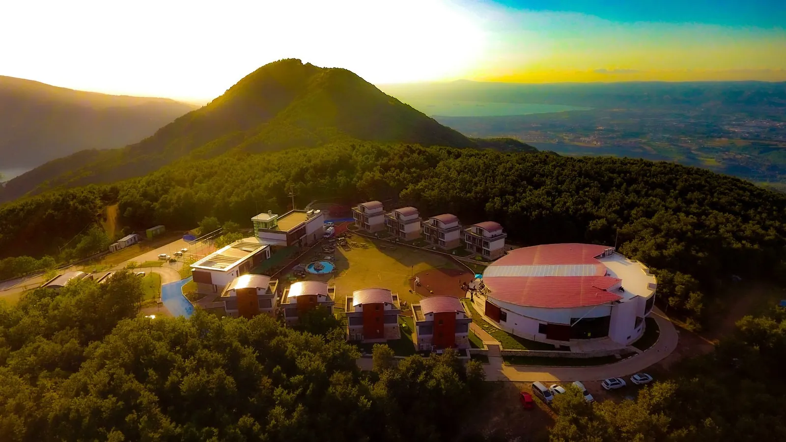 Aerial view of HK Resort: camp area between mountains and forest